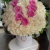 A beautiful arrangement of white and pink roses elegantly displayed in a pristine white box.