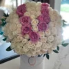 A beautiful arrangement of white and pink roses elegantly displayed in a pristine white box.