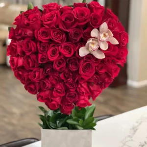 A heart-shaped arrangement featuring vibrant red roses and delicate orchids, symbolizing love and beauty.