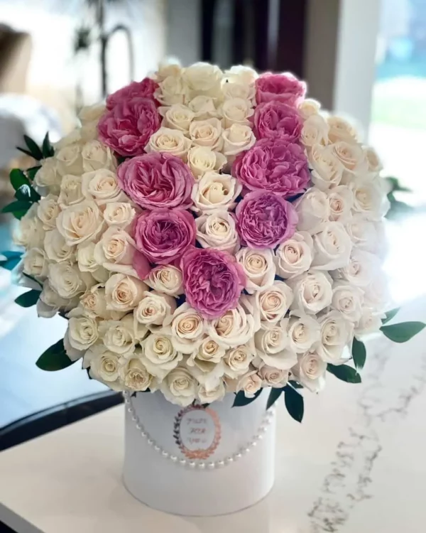 A beautiful arrangement of white and pink roses elegantly displayed in a pristine white box.