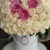 A beautiful arrangement of white and pink roses elegantly displayed in a pristine white box.