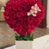 A heart-shaped arrangement featuring vibrant red roses and delicate orchids, symbolizing love and beauty.