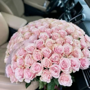 A large bouquet of pink roses elegantly arranged in the back seat of a car, adding a touch of beauty and romance.