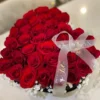 A heart-shaped box filled with vibrant red roses and delicate baby's breath, symbolizing love and affection.