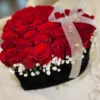 A heart-shaped box filled with vibrant red roses and delicate baby's breath, symbolizing love and affection.