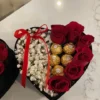 A heart-shaped box filled with vibrant roses and assorted chocolates, symbolizing love and affection.