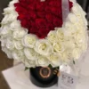 A heart-shaped arrangement of red and white flowers, beautifully crafted to create a romantic and elegant display.