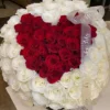 A heart-shaped arrangement of red and white flowers, beautifully crafted to create a romantic and elegant display.