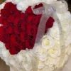 A heart-shaped arrangement of red and white flowers, beautifully crafted to create a romantic and elegant display.