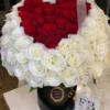 A heart-shaped arrangement of red and white flowers, beautifully crafted to create a romantic and elegant display.