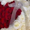 A heart-shaped arrangement of red and white flowers, beautifully crafted to create a romantic and elegant display.