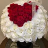 A heart-shaped arrangement of red and white flowers, beautifully crafted to create a romantic and elegant display.