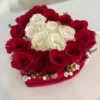 A heart-shaped arrangement featuring vibrant red and elegant white roses, symbolizing love and purity.