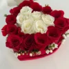 A heart-shaped arrangement featuring vibrant red and elegant white roses, symbolizing love and purity.