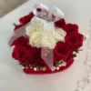 A heart-shaped arrangement featuring vibrant red and elegant white roses, symbolizing love and purity.