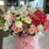 A vibrant bouquet of flowers arranged beautifully in a stylish pink bag, showcasing a delightful mix of colors.