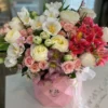 A vibrant bouquet of flowers arranged beautifully in a stylish pink bag, showcasing a delightful mix of colors.