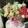 A vibrant bouquet of flowers arranged beautifully in a stylish pink bag, showcasing a delightful mix of colors.