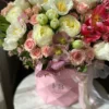 A vibrant bouquet of flowers arranged beautifully in a stylish pink bag, showcasing a delightful mix of colors.