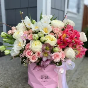 A vibrant bouquet of flowers arranged beautifully in a stylish pink bag, showcasing a delightful mix of colors.