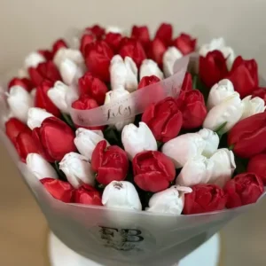 A vibrant bouquet featuring red and white tulips arranged elegantly in a decorative vase.