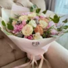 A lovely bouquet featuring pink and white flowers placed on a table, creating a serene and inviting atmosphere.