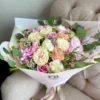 A lovely bouquet featuring pink and white flowers placed on a table, creating a serene and inviting atmosphere.