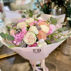 A lovely bouquet featuring pink and white flowers placed on a table, creating a serene and inviting atmosphere.