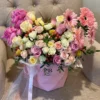 A vibrant bouquet of flowers arranged beautifully in a stylish pink bag, showcasing a delightful mix of colors.