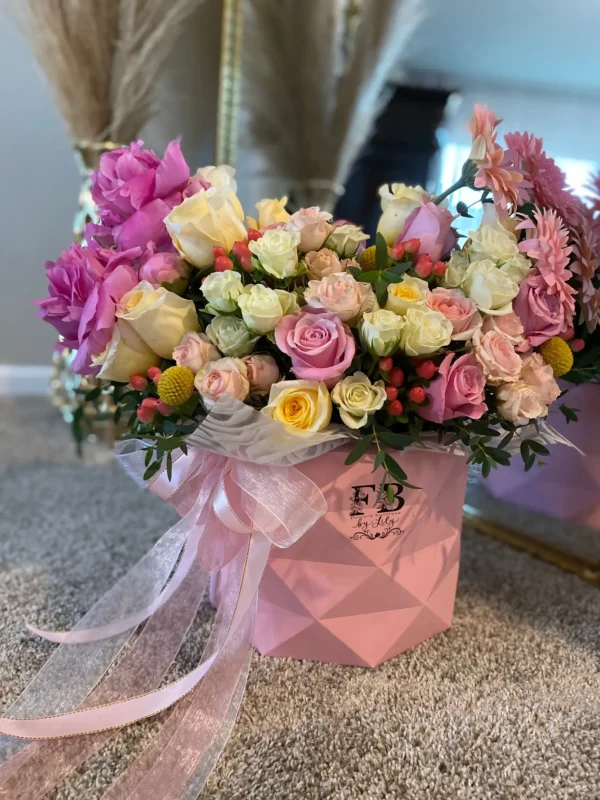 A vibrant bouquet of flowers arranged beautifully in a stylish pink bag, showcasing a delightful mix of colors.