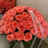 A large bouquet of pink roses elegantly arranged on a table, showcasing their vibrant color and lush petals.