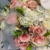 A white box adorned with delicate pink roses and elegant orchids, creating a charming floral arrangement.